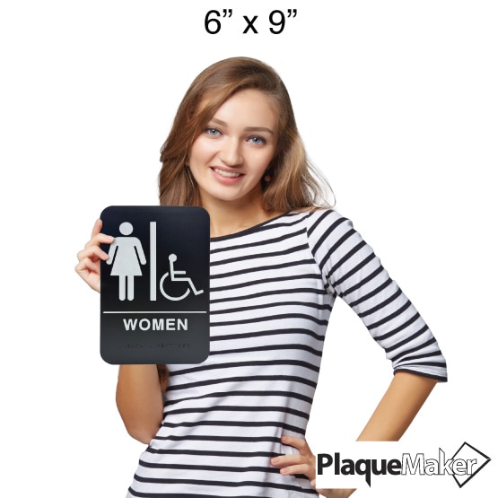 Size Guide Of Woman Holding Black And White Plastic Sign With Women And Wheelchair Icons Above Women Text With Braille